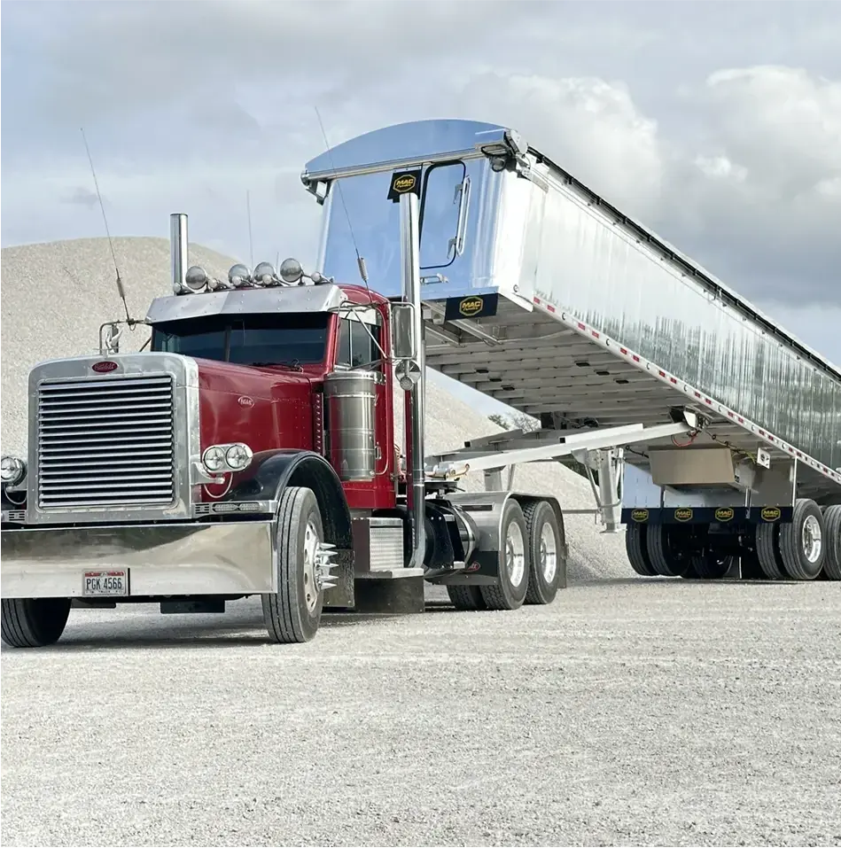 MAC Dump Trailer lifted attached to a Peterbilt single cab semi truck.