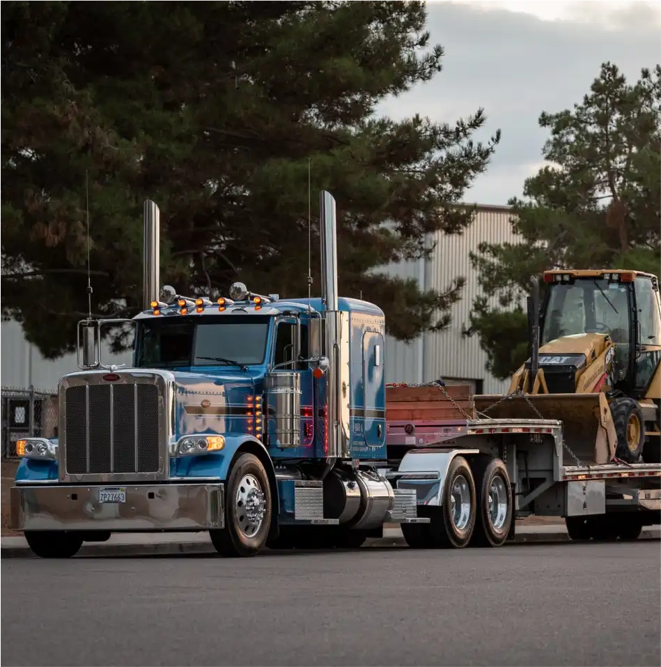 Peterbilt semi truck with MAC Trailer Drop Deck attached hauling a bulldozer.